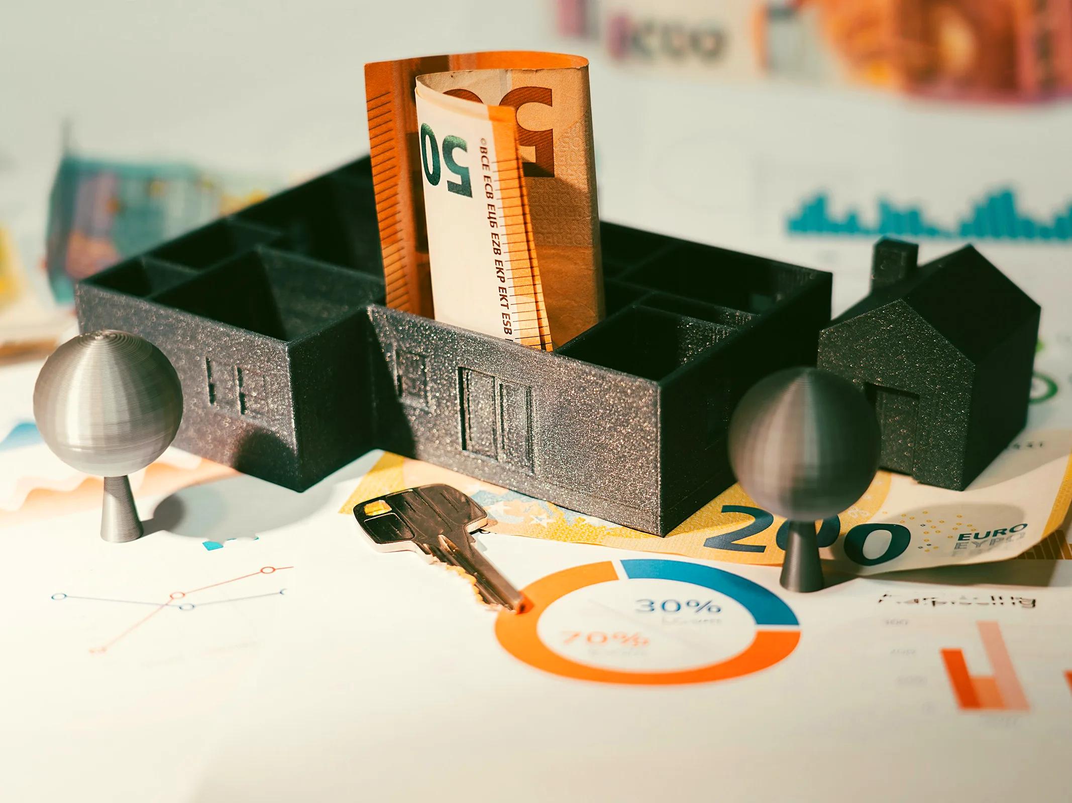 Model domu s eurobankovkami a klíčem