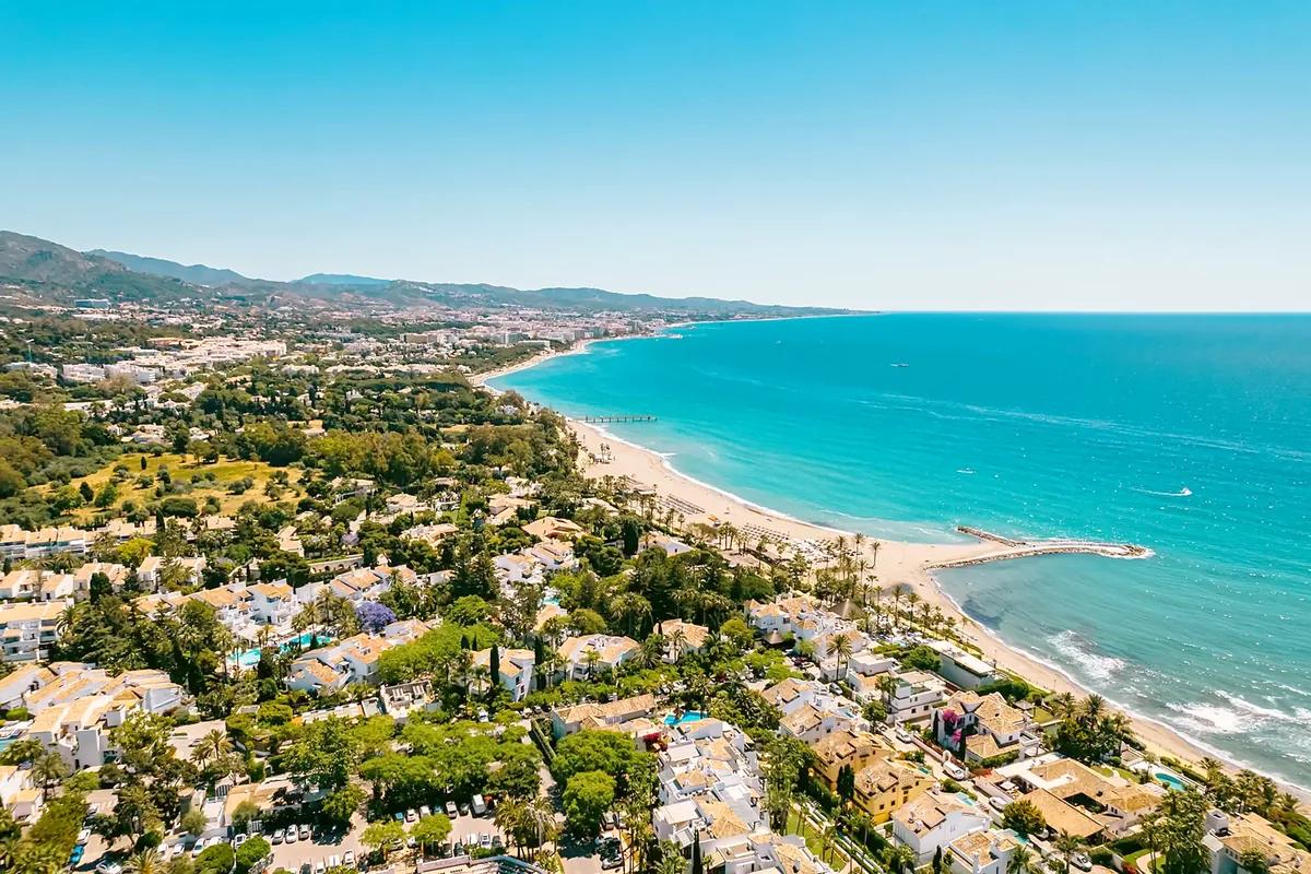 Zelené pobřeží Costa del Sol s dlouhou pláží a tyrkysovým mořem